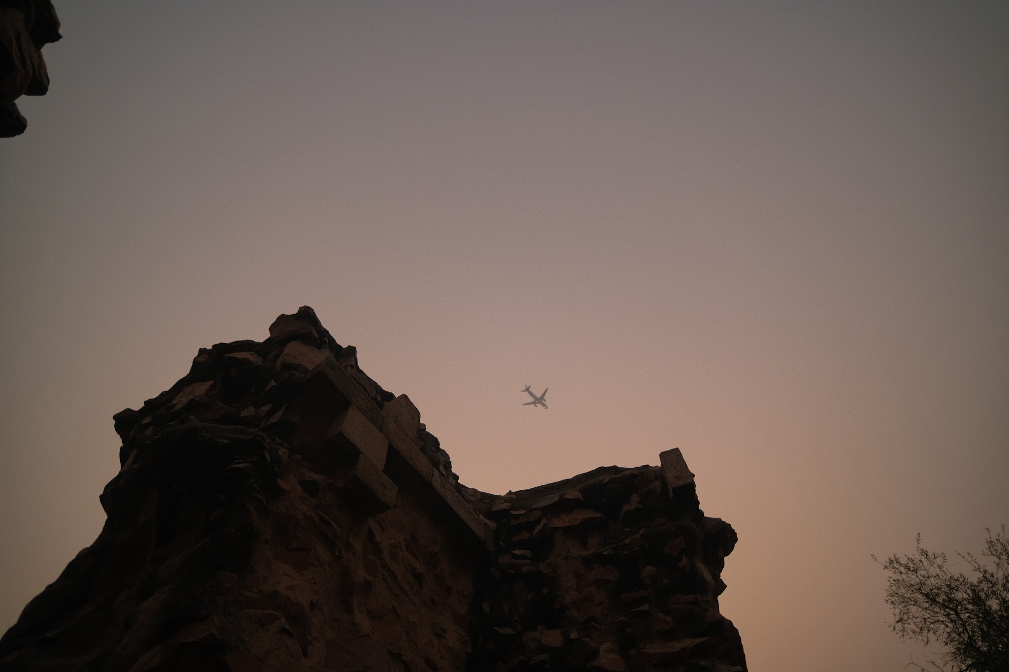 airplane crossing dusk above rock formations